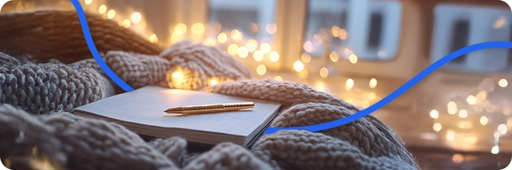 Carnet et stylo dans une atmosphère chaleureuse, symbolisant le bilan spirituel de 2025, l’introspection et l’écriture des intentions pour accueillir le renouveau de 2026.