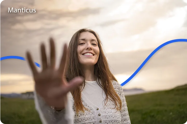 Lächelnde Frau in der Natur hebt die Hand, Symbol für Offenheit für Veränderung und positive Energie des Freitag den 13. in der Numerologie.